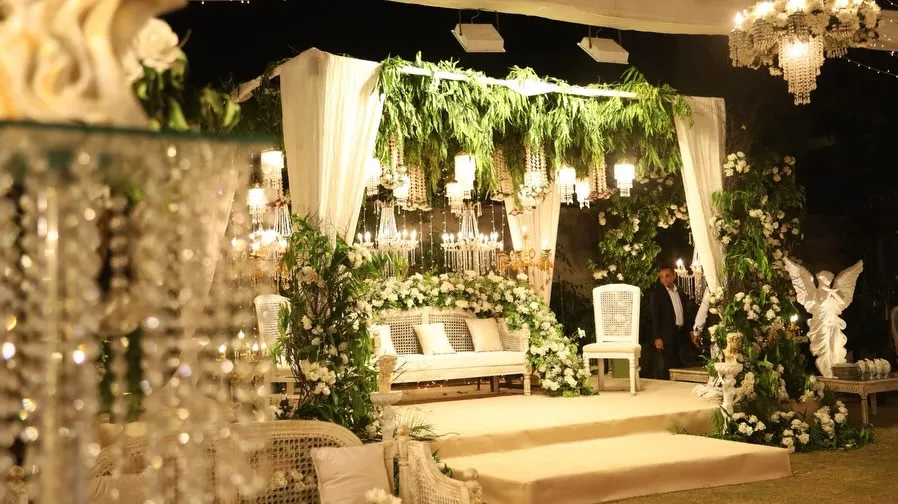 White floral stage with crystal chandeliers by Events by OT